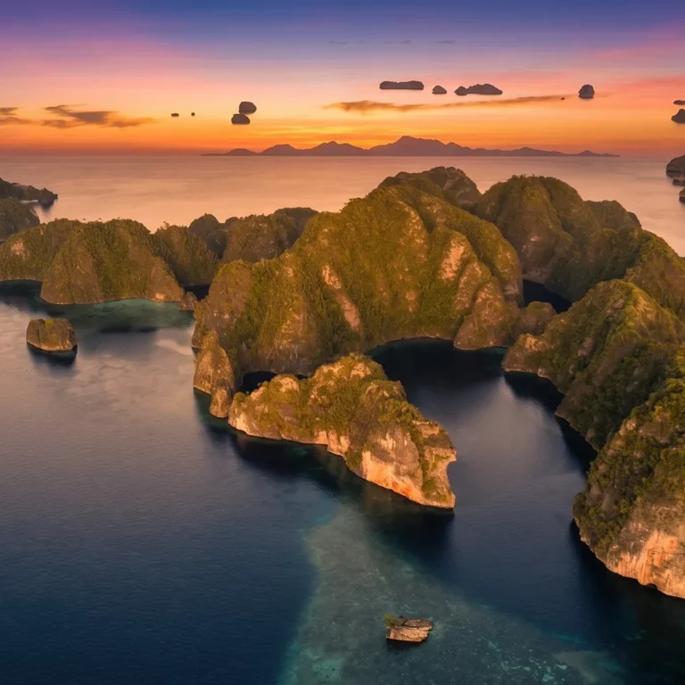 Limestone islets scattered across shallow water in Raja Ampat at sunset